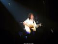 Brian May con la chitarra acustica rivolto verso il pubblico